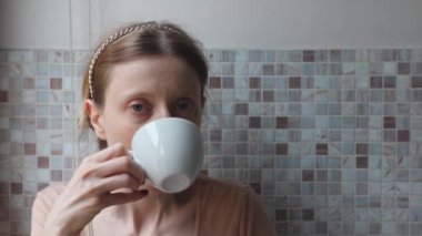 Bir fincan kahve içen bir kadın.