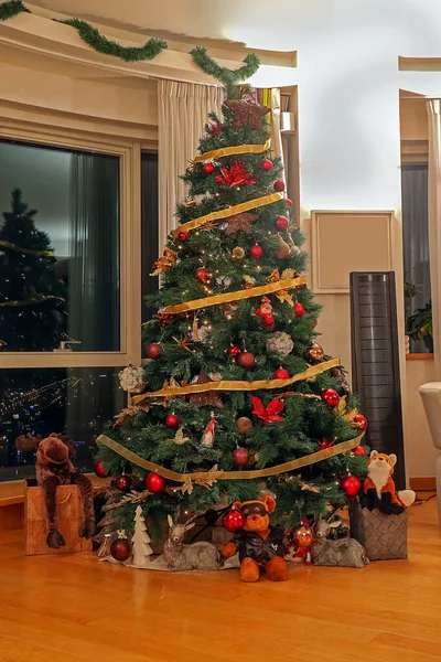 床の下にプレゼント付きのリビングルームの内部にカラフルな装飾が施されたクリスマスツリー — ストック写真