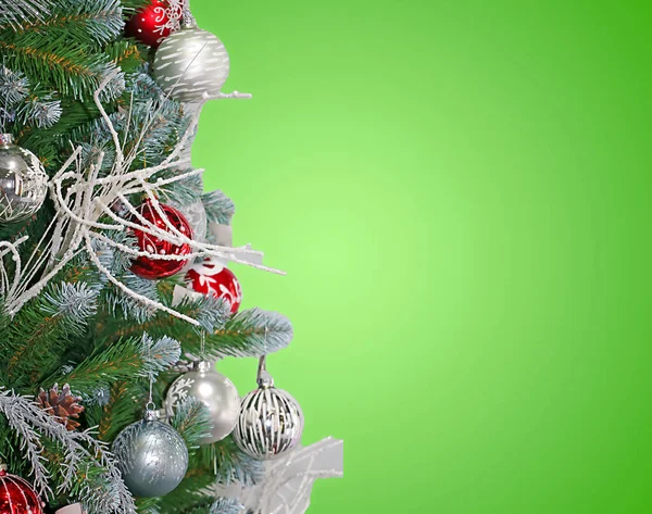 附有装饰品及绿色背景的喜庆圣诞树的细部 供人在侧面抄袭 — 图库照片