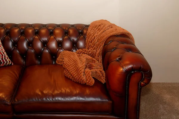 一半复古光泽的棕色皮沙发 旁边有毛毯 — 图库照片