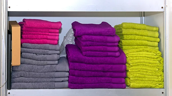 家用电器商店里架子上成堆的彩色毛巾 — 图库照片