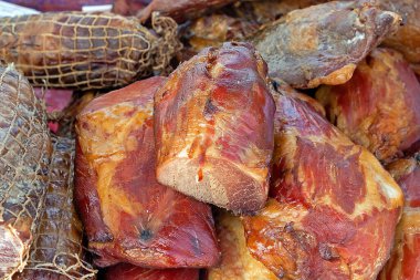 Pile of smoked bacon and ham cured pork meat sold on local market stall