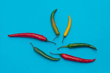 Renkli baharatlı biber yığını ve mavi arka planda izole edilmiş habanero acı biber.