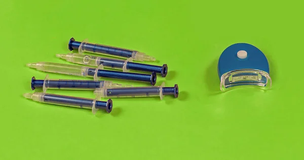 青のラッドランプと自宅で歯科治療のためのゲルで満たされたプラスチック製の注射器と歯のホワイトニングツール — ストック写真