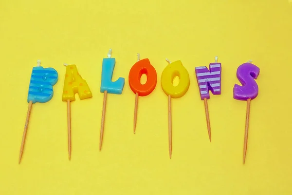 Ballonnen Woord Letters Decoratieve Kleurrijke Kaarsen Geïsoleerd Gele Achtergrond — Stockfoto