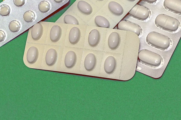 Куча Медицинских Таблеток Упаковке Белые Волдыри Изолированы Зеленом Фоне — стоковое фото