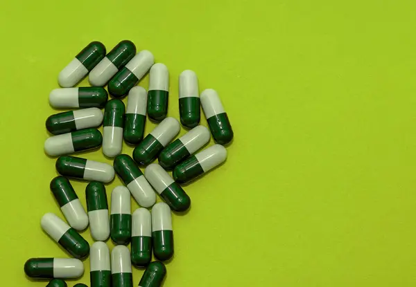 Белые Зеленые Медицинские Капсулы Углу Зеленом Фоне Лайма — стоковое фото