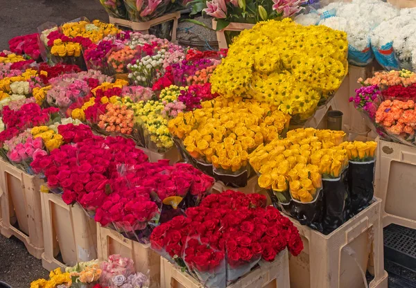 外の市場で売られているバラなどの色とりどりの花 — ストック写真