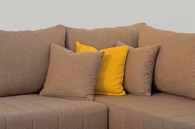 Kanepe köşesinde dekoratif kumaş yastık yığını.