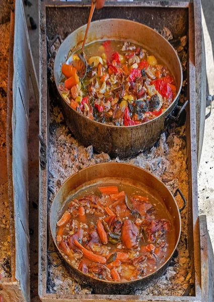 Stock image Cooked vegetable and meat stews in metal pots outside on a market