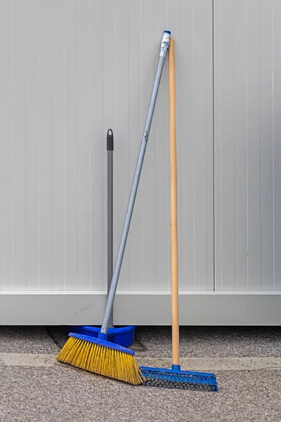 Retro brooms cleaning equipment tools outside on a city street