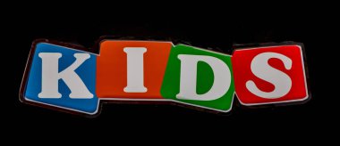 Çocukların renkli harfleri dışarıdaki siyah bina cephesinde.