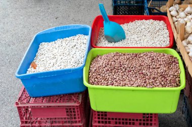 Dışarıda bir markette organik çiğ fasulye yığınları satılıyor.