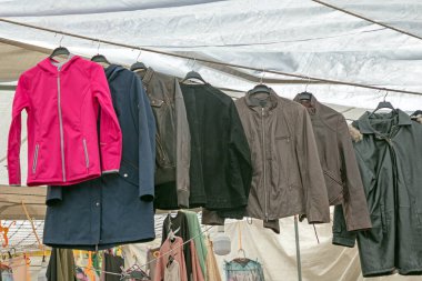 Kışlık moda ceketleri bir marketin önünde asılı duruyor.