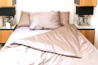 Odanın içinde pamuklu yatak olan otel yatağı.