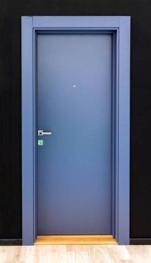 Kapalı ahşap gri kapı iç koridorda.