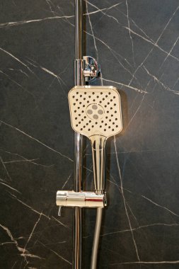 Modern duş musluğu banyo duvarında asılı.