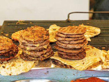 Marketin dışında ızgarada sığır burger yığını.