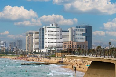 Tel Aviv, İsrail - 23 Mayıs 2018: Yaz günü Tel Aviv 'de bir sahil kıyısında İsrail' de çok sayıda turistin yürüdüğü ve yüzdüğü binalar.