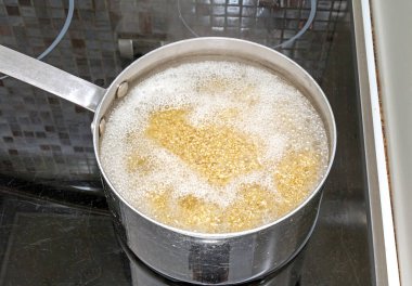 Mutfaktaki ocağın içinde kaynar suda kinoa var.