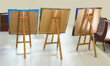 Ahşap sehpalar, bahçenin dışında asılı duran tablolar.