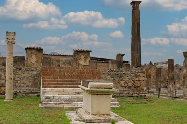 Pompeii şehrinde taş sütunları ve gökyüzünde bulutları olan eski kalıntılar.