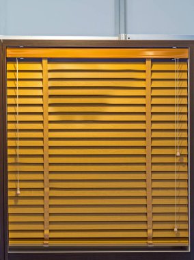 Kahverengi ahşap Venedik penceresi evin içindeki bir duvarda panjurlar.