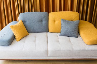 Tekstil döşemeleri ve arkasında yastıklar olan modern renkli kanepe.