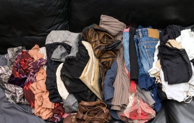 Odanın içinde bir yığın temiz, dağınık giysi var.