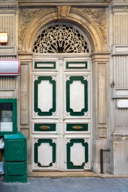 Eski kapalı, çift katlı ahşap giriş kapısı.