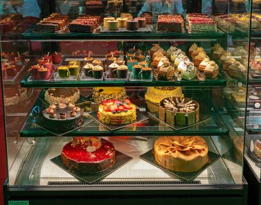 Kapalı cam pencere, pastanenin içindeki raflarda tatlı kekler.
