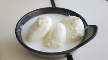 Rasmalai ya da Ras malai Rasamalei yemek için kaşık kullanın. Hint tatlı sütü.