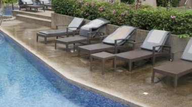 Gündüz yatağının yakınındaki havuz manzarası modern tasarım tesislerinde dinlenme havuzu üzerinde yağmur damlası suyu olan doğal tatil arka planı.