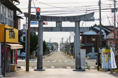 14 Kasım 2022: Fukuoka, Japonya: Günbatımında Miyajidake Tapınağı 'nın torii taş giriş kapısı ve tapınağın önündeki yerel sokak manzarası