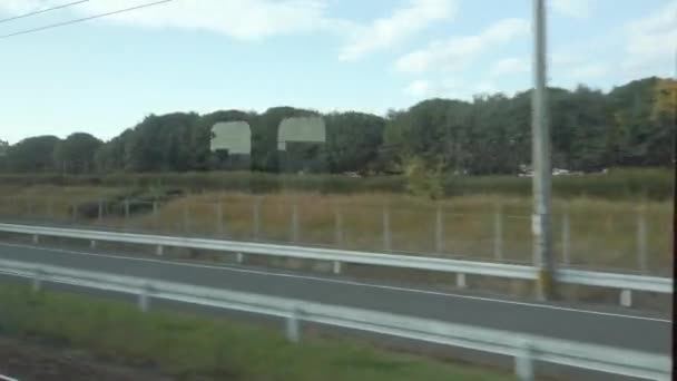 在日本白天列车快速行驶的同时 通过火车窗口看到当地的乡村风景 在铁路轨道一侧看到自然景观 — 图库视频影像