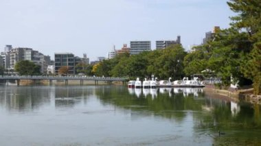 Japonya, Hakata, Fukuoka 'daki Ohori halk parkındaki göl gölünün doğal manzara manzarası. Sonbahar günü açık mavi gökyüzü altında ve şehir yatay hat üzerinde.