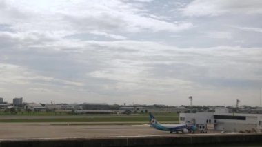 December 6,2022:Donmuang airport, Bangkok,Thailand:boeing b737 airplane park in airport bay area while ground service operating and airplane take off from airport