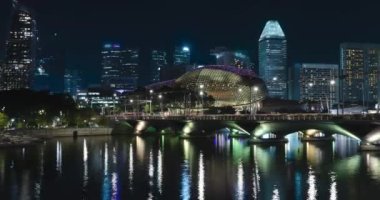 Singapur marina körfezi manzarası. Yükselen gökdelen binaları ve cadde trafiği. Singapur 'un gece ve şehir manzarasının ünlü simgesi.