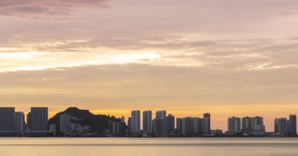 海岸近くに高層ビルが建ち並ぶウォーターフロント都市のタイムラプスシルエットやバニラの黄昏の空と日没の時間帯 空に雲が動く風景 — ストック動画