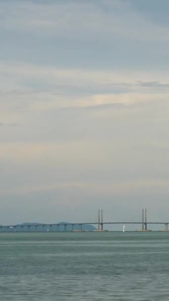 在槟城大桥上方 垂直的延时云彩落日在连接槟城与落日的香草天空时间的海洋上 是马来西亚人著名的地标 交通桥梁 — 图库视频影像