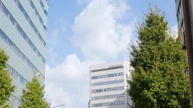 view to the glass modern office building under clear blue sky in autumn daytime in fukuoka japan, office financial district area in japan