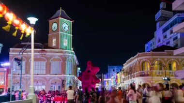 January 27,2023:Phuket old town,Thailand: timelapse landscape night view with light illumination on the colonial architecture building with crowded people in Phuket Festival 2023 night time