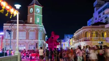 January 27,2023:Phuket old town,Thailand: timelapse landscape night view with light illumination on the colonial architecture building with crowded people in Phuket Festival 2023 night time