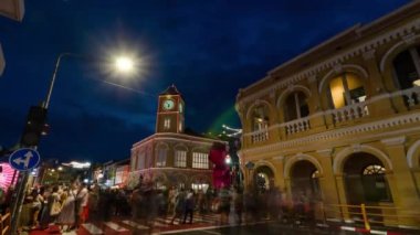 January 27,2023:Phuket old town,Thailand: timelapse landscape night view with light illumination on the colonial architecture building with crowded people in Phuket Festival 2023 night time