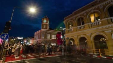 January 27,2023:Phuket old town,Thailand: timelapse landscape night view with light illumination on the colonial architecture building with crowded people in Phuket Festival 2023 night time