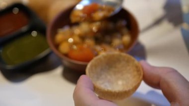Close up while filling chili sauce into hollow of Panipuri a popular Indian street food. Panipuri a street snack in India, Nepal, Bangladesh, Pakistan