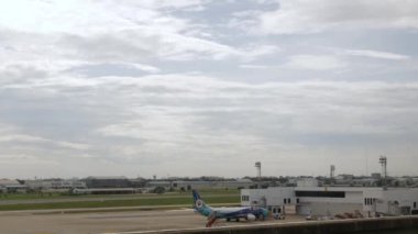 December 6,2022:Donmuang airport, Bangkok,Thailand:boeing b737 airplane park in airport bay area while ground service operating and airplane take off from airport