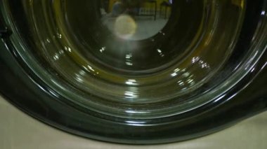 close up to washing machine washes laundry colored clothing and sheets washing machine and dryer working at professional industrial laundry