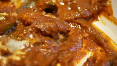 use hand grab naan bread to dip into the red chicken butter curry indian food, Chicken Masala asian traditional vegetarian masala gravy meal with vegetables and white sauce