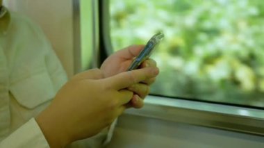 A man in a commuter train subway metro traveling and uses the smartphone happy tourist travel by train  Freedom trip on vacation time holiday weekend.use smartphone in public transportation